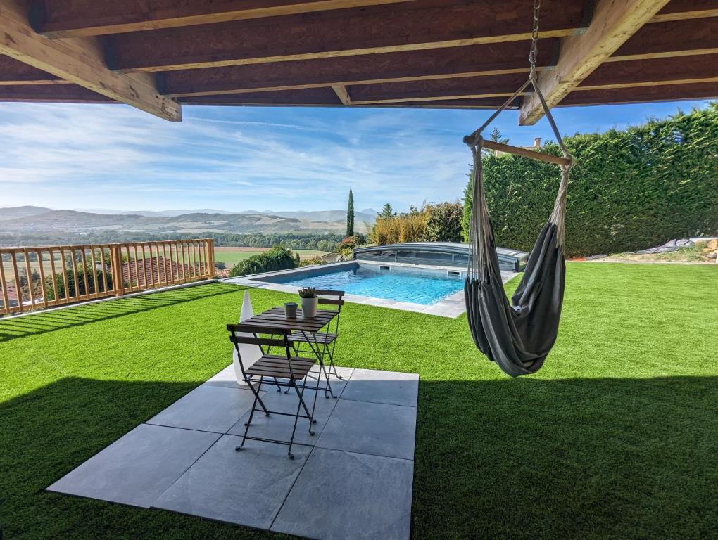 een patio met een hangmat en een zwembad bij Bel appartement 75m2 in Mirefleurs