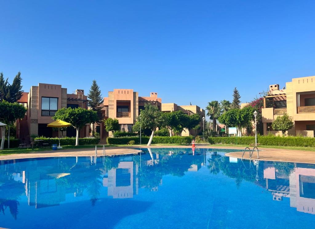 ein großer Pool mit Gebäuden im Hintergrund in der Unterkunft Luminous apartment with pool view in Marrakesch