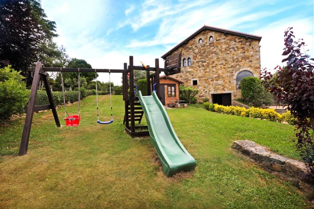 un parque infantil con un tobogán en un patio en Hotel Spa San Marcos, en Santillana del Mar