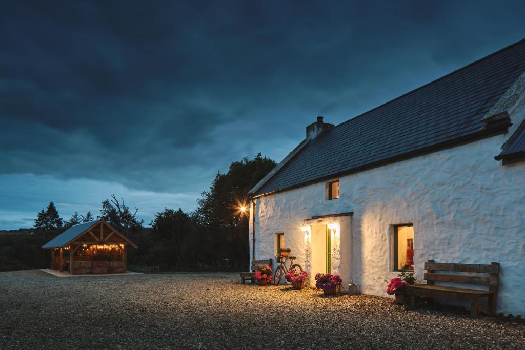 a white barn at night with a dark sky at Maggie Deenys Cottage 