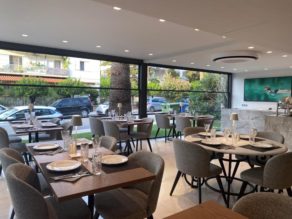 a restaurant with tables and chairs and a large window at Brasil Suites Boutique Hotel in Athens