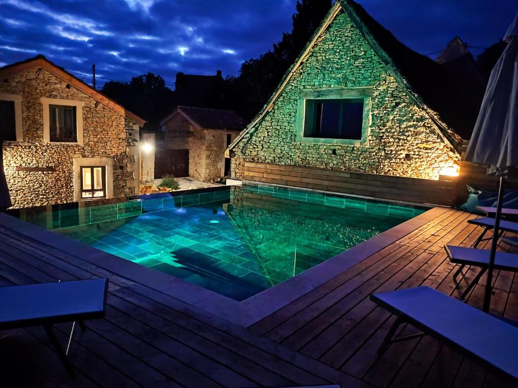 une maison avec une piscine en face d'un bâtiment dans l'établissement L'Escapade Authentique, à Brouchaud