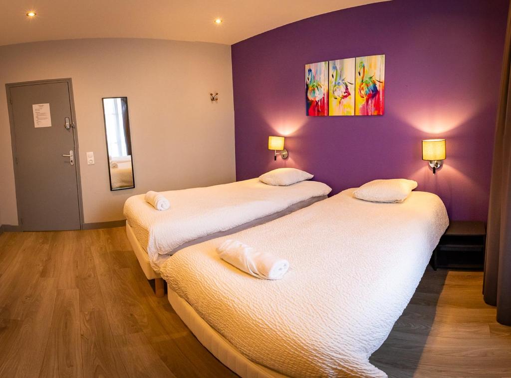 duas camas num quarto com paredes roxas em Résidence Hera Paris Orly Aéroport em Villeneuve-le-Roi