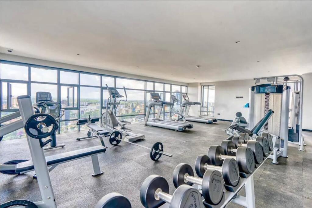 a gym with treadmills and machines in a building at Cosy Home in Westlands in Nairobi