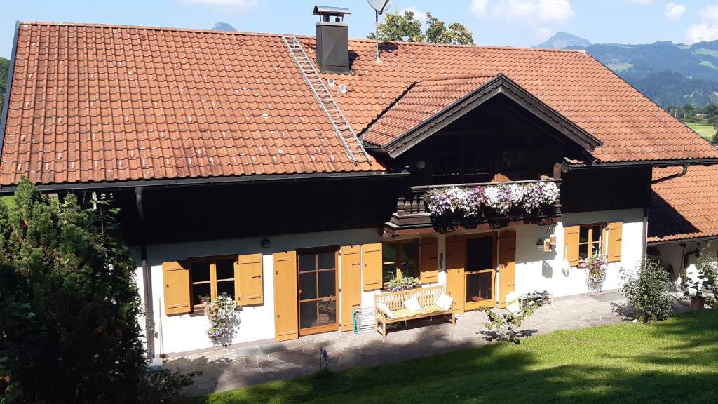 una casa con puertas amarillas y techo rojo en Ferienwohnung im Brechstubenweg en Kiefersfelden