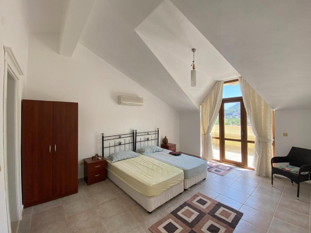 1 dormitorio con 1 cama y 1 silla en Mavi Ev en Marmaris
