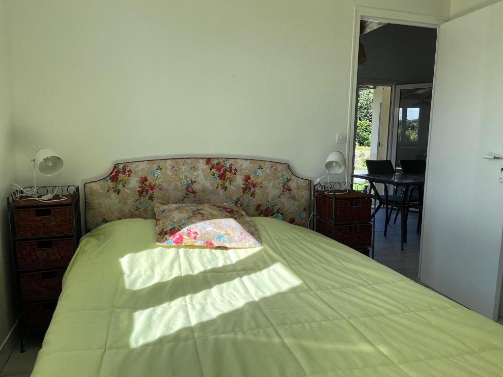ein Schlafzimmer mit einem Bett mit einer grünen Bettdecke in der Unterkunft Villa Bleu soleil in Pornic