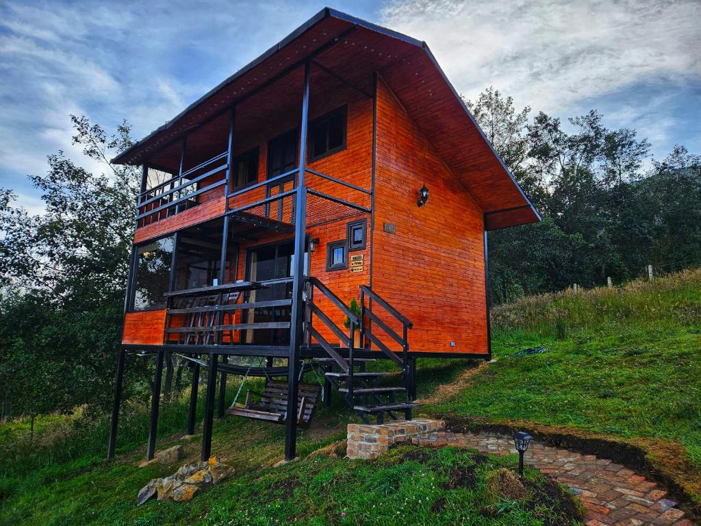 a house on a hill with a staircase in front of it at Glamping Hakuna Matata in Monguí