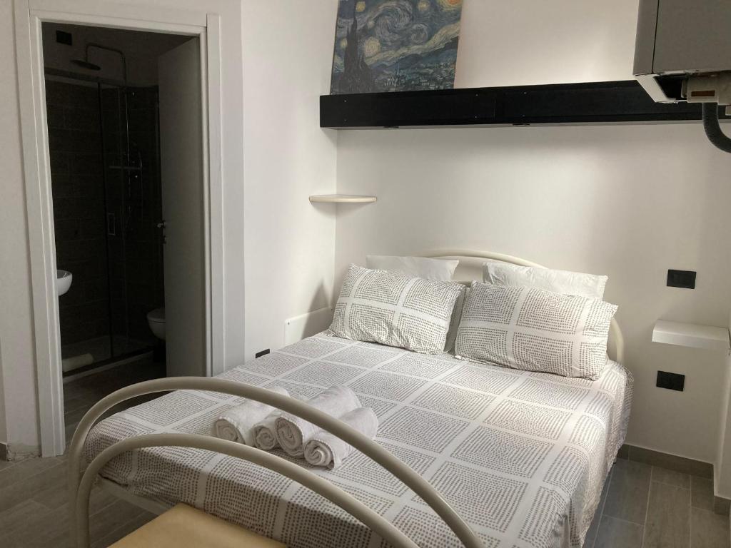 1 dormitorio con 1 cama con sábanas y almohadas blancas en James house, en Teramo