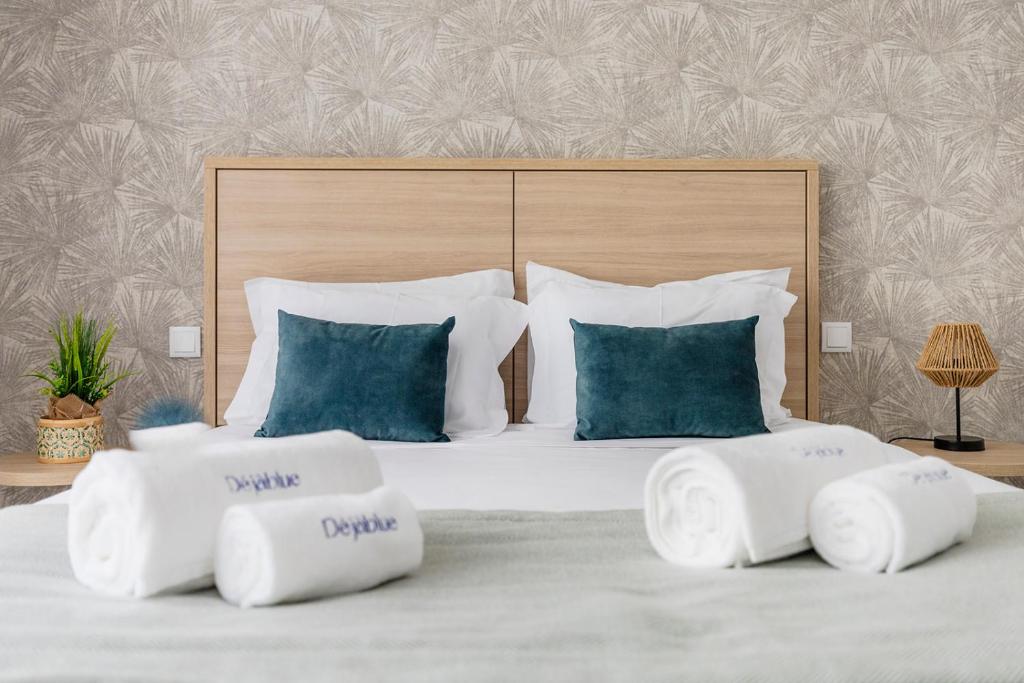 - une chambre avec un grand lit blanc et des oreillers bleus dans l'établissement Blue Apartments, à Leiria