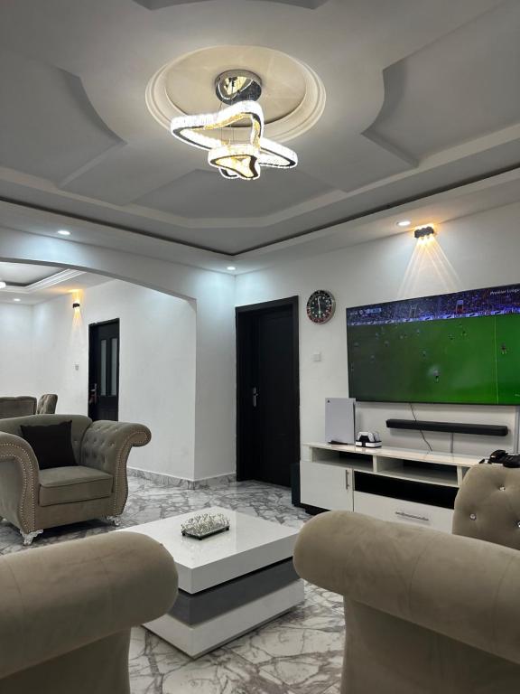 - un salon avec un canapé et une télévision dans l'établissement KAIR Service Apartments, à Benin City