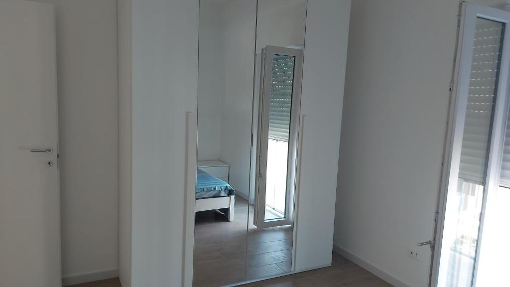 een spiegel in een witte kamer met een slaapkamer bij Villa SereMar in Pulsano