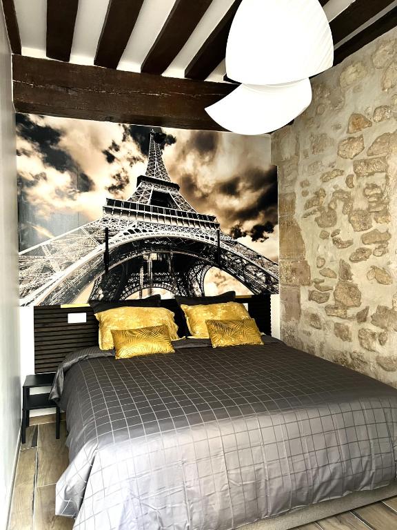 - une chambre avec un lit orné d'une fresque murale représentant la tour Eiffel dans l'établissement MARAIS Appartement 2 Chambres 2 Salles de bain - SPA JACUZZI !, à Paris