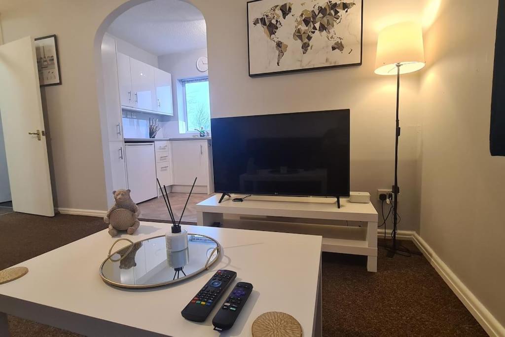 a living room with a tv and a table at An Idyllic Essex Escape in Witham