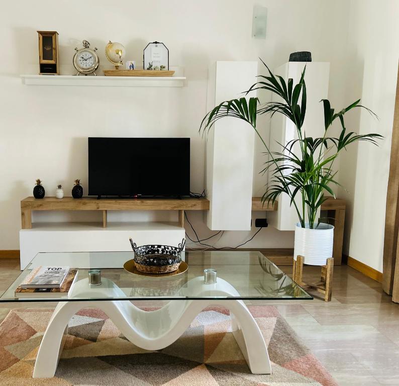 a living room with a glass table and a tv at Giada Apartment in Verona