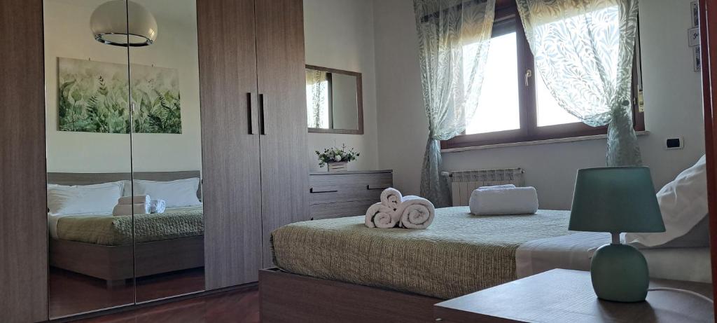 1 dormitorio con 2 camas individuales y espejo en Regina Ciclarum Suite, en Fiumicino