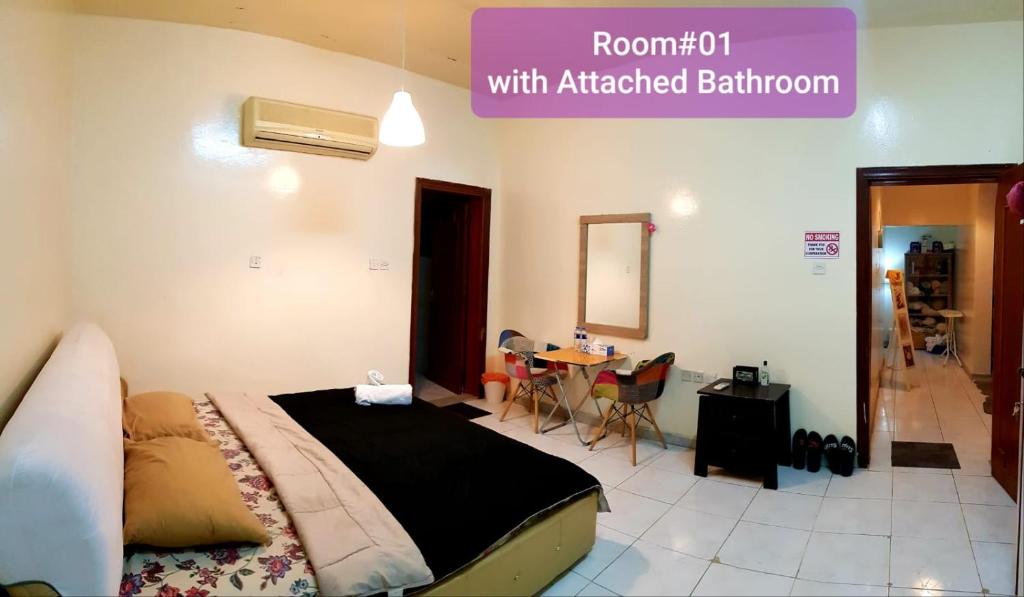 1 dormitorio con 1 cama y 1 mesa con sillas en Bzxmax Guest House, en Al Ain