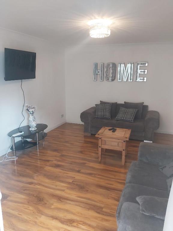 a living room with a couch and a table at super comfortable 3 bed house in Houghton Regis