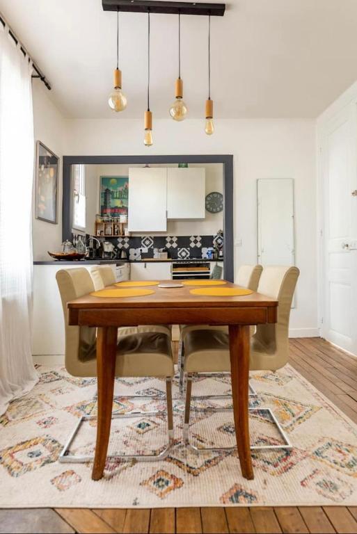 a dining room with a wooden table and chairs at Maison confortable avec jardin à 2 pas de Paris in Fontenay-sous-Bois