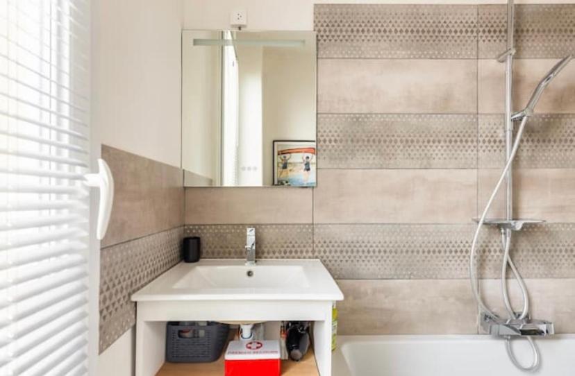 a bathroom with a sink and a mirror and a tub at Maison confortable avec jardin à 2 pas de Paris in Fontenay-sous-Bois