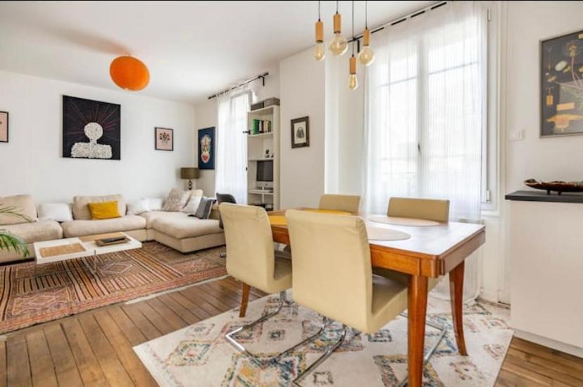a living room with a dining table and a couch at Maison confortable avec jardin à 2 pas de Paris in Fontenay-sous-Bois