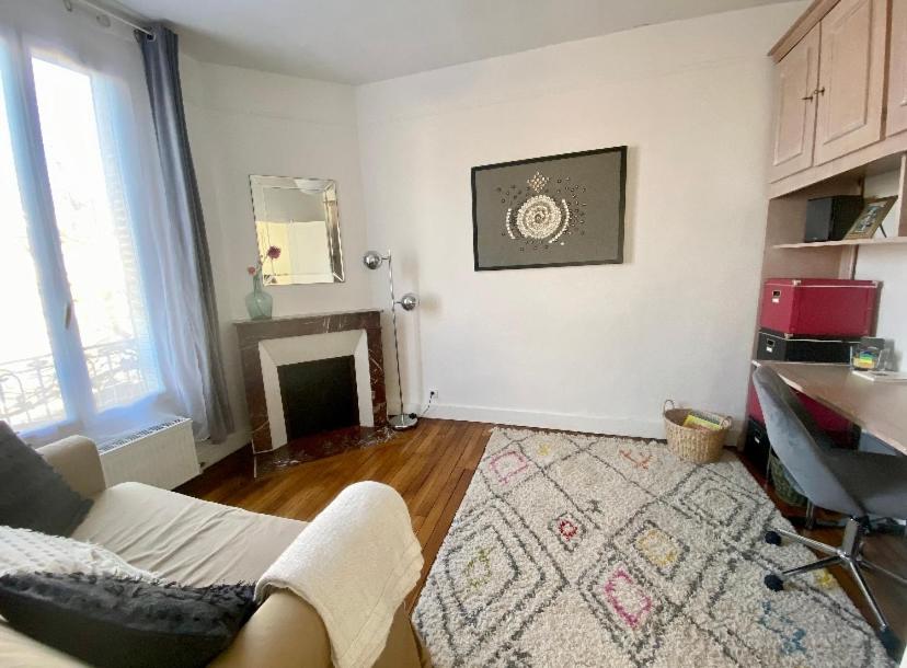 a living room with a couch and a fireplace at Maison confortable avec jardin à 2 pas de Paris in Fontenay-sous-Bois