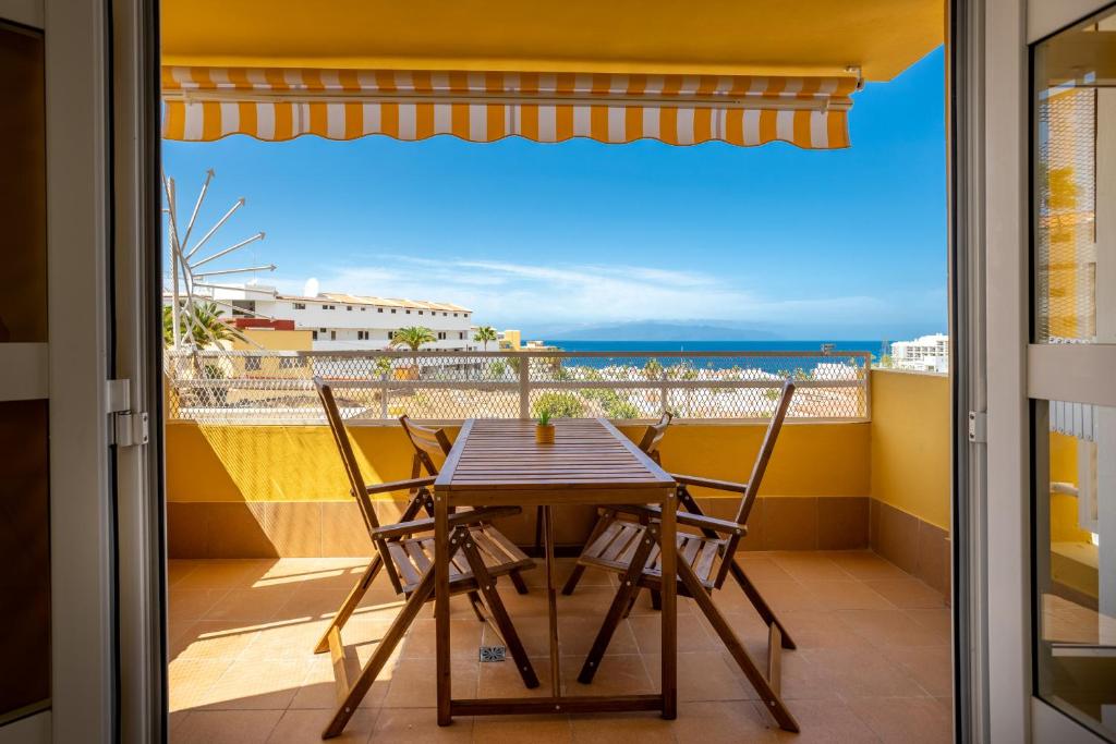a table and chairs on a balcony with a view of the ocean at Great Ocean View Torviscas Beach Home by LoveTenerife in Adeje