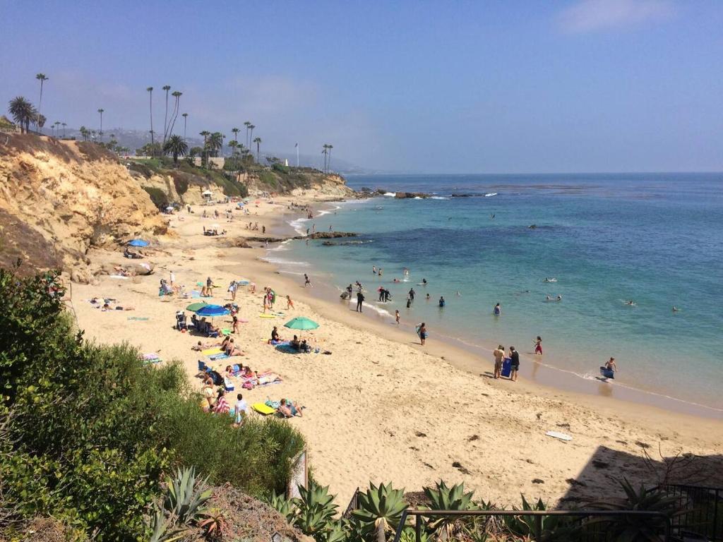 a group of people on a beach with the ocean at laguna beach cottage home in Laguna Beach