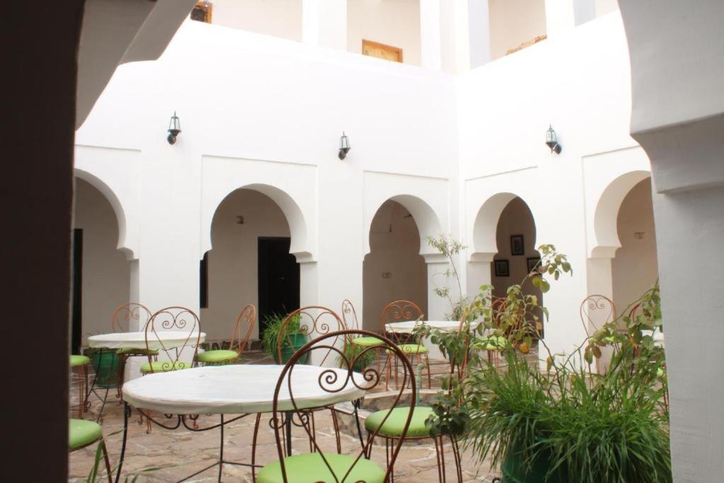 a courtyard with tables and chairs in a building at Riad Amodou in Tinerhir