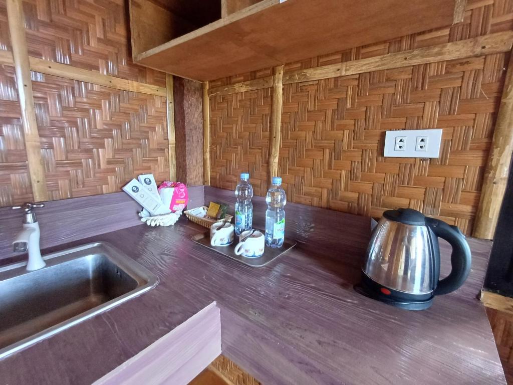a kitchen counter top with a sink and a kettle at Almare Guest House Siquijor in San Juan