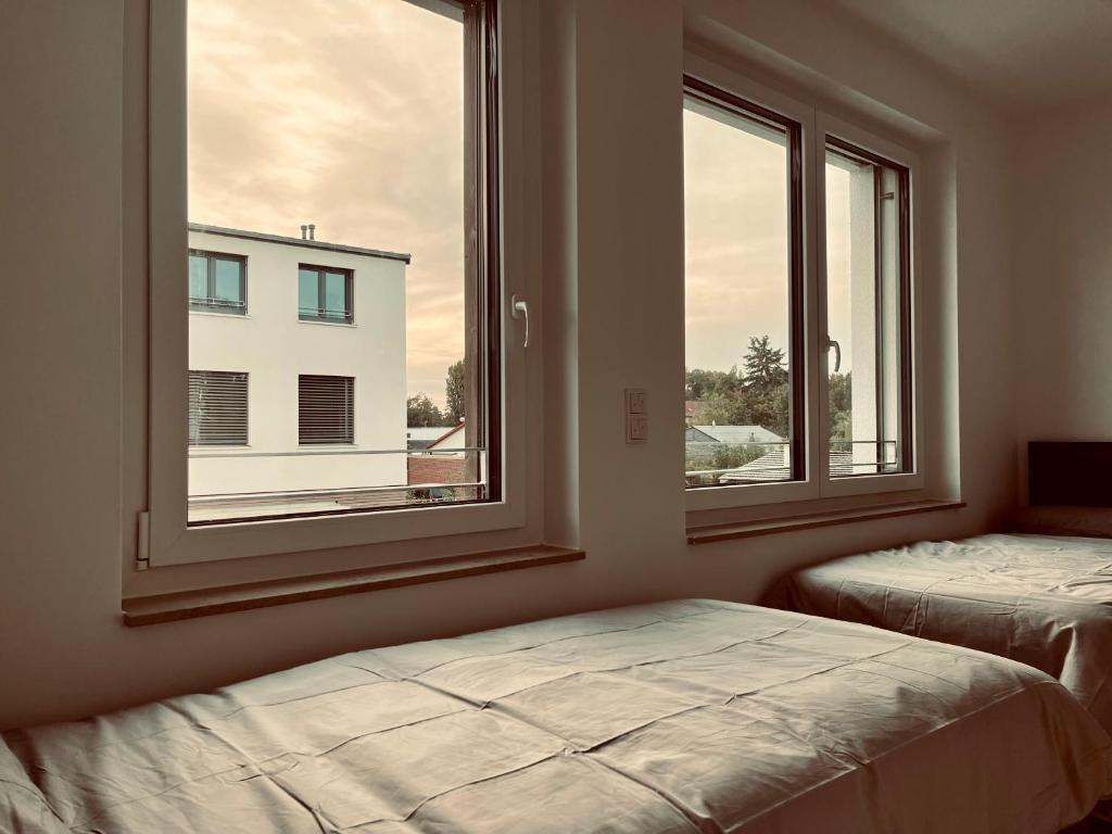 a bedroom with two beds and two windows at Guestroom Hannover Messe in Hannover