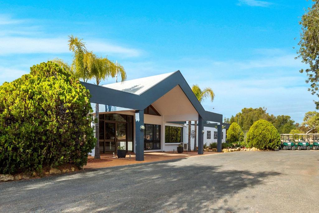 a building with a palm tree in front of it at Comfort Inn & Suites Riverland in Barmera