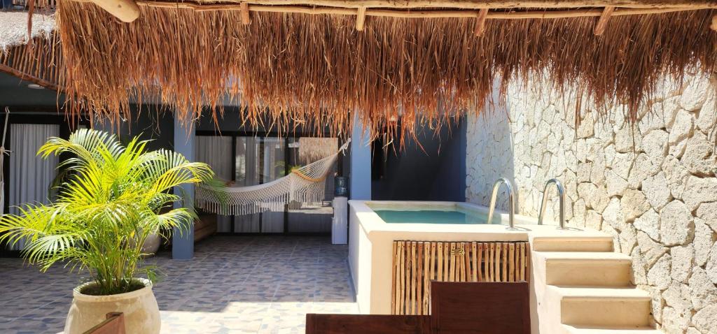a resort with a sink and a hammock under a straw roof at Kin Tulum House downtown in Tulum