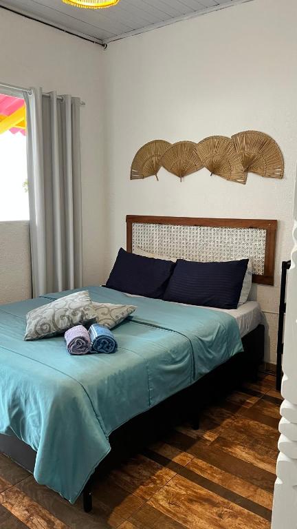 a bedroom with a bed with blue sheets and a window at Pousada Suítes Sete Mares in Guarujá
