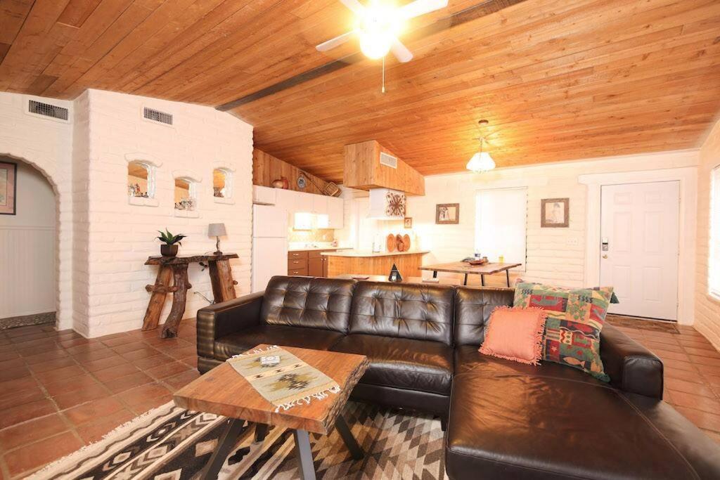 a living room with a leather couch and a table at Cozy Adobe in Pahrump