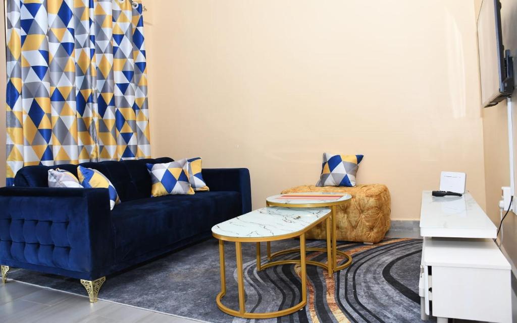 ein Wohnzimmer mit einem blauen Sofa und einem Tisch in der Unterkunft Intellicents Apartments in Kisumu