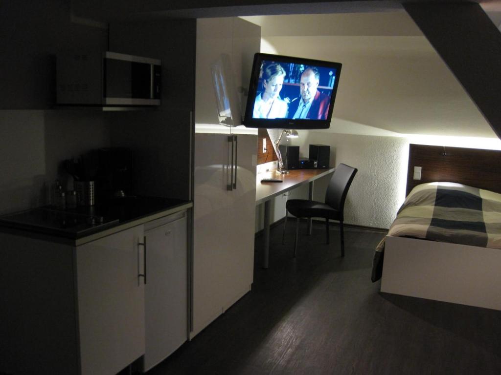 ein Hotelzimmer mit einem Bett und einem TV an der Wand in der Unterkunft Apartment in Mönchengladbach