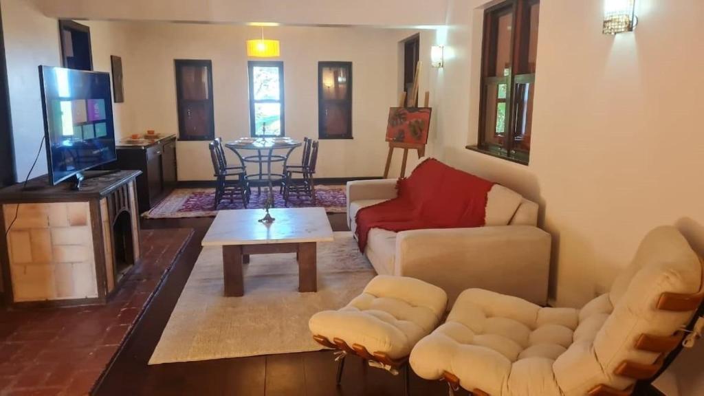 uma sala de estar com um sofá e uma televisão em Casa Temporada - Petrópolis/RJ em Petrópolis
