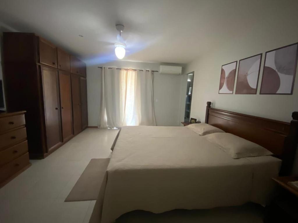 ein Schlafzimmer mit einem großen Bett und einem Fenster in der Unterkunft Aconchego casa para temporada in São Pedro da Aldeia