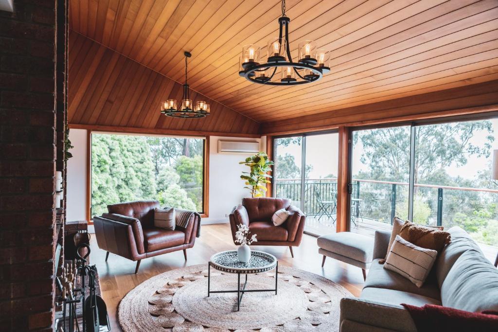 sala de estar con sofá, sillas y ventanas en High Grange Luxury Mountain Retreat - Pool, Spa, Sauna en Kalorama
