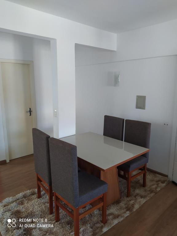 een eettafel met 2 stoelen en een witte tafel bij Cobertura Céu Aberto in Guaporé