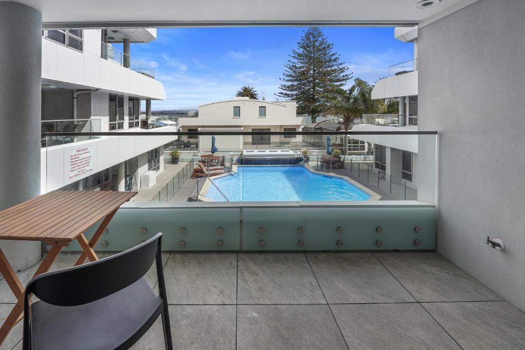 a view from the balcony of a building with a swimming pool at Anchorage Oasis - Mt Maunganui Holiday Apartment in Mount Maunganui