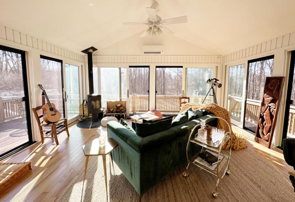 uma sala de estar com um sofá verde e algumas janelas em Entertainer's Dream, Designer Getaway em Brookfield