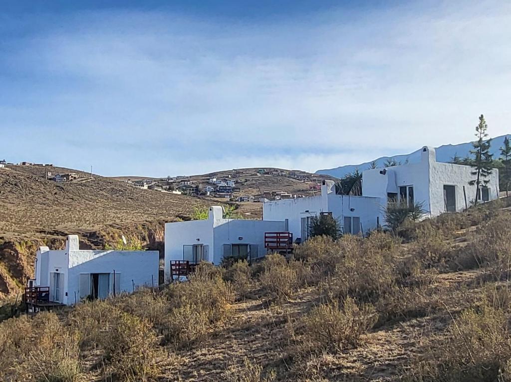een groep witte gebouwen op een heuvel bij El Vigía del Valle in Tafí del Valle