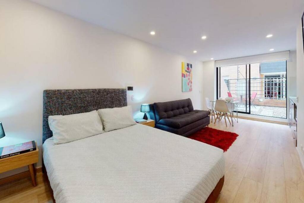 1 dormitorio con 1 cama grande y 1 sofá en Apartamento con Terraza cerca a Unicentro, en Bogotá