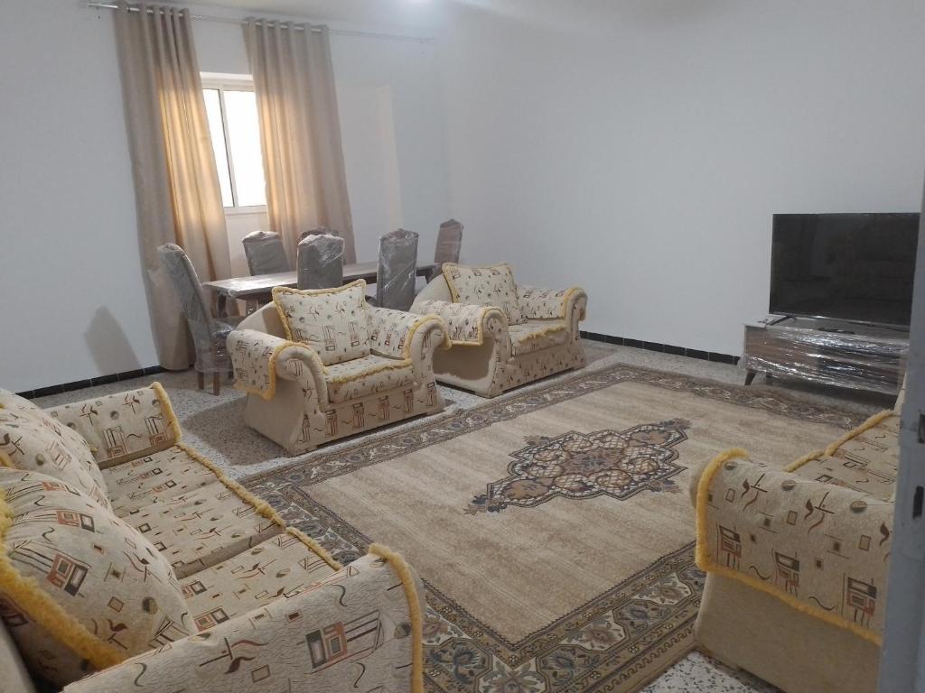 a living room with couches and a flat screen tv at Meilleure Escale à Gabes in Al Mayyitah