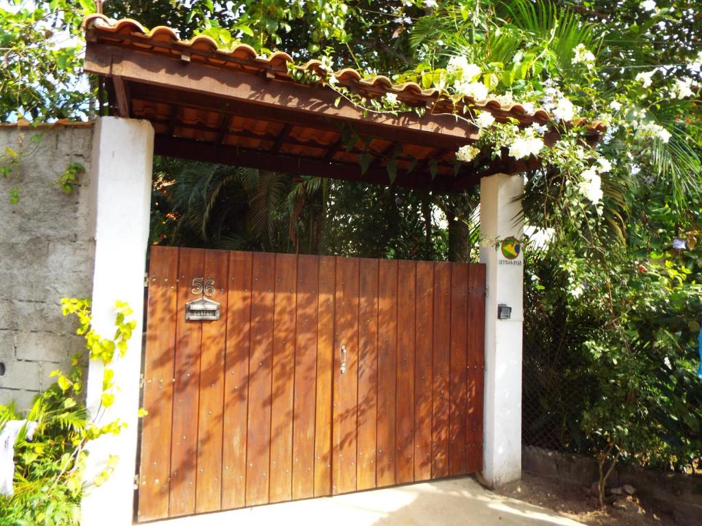 a wooden gate with a roof on top of it at Aldeia Itamambuca Chalé Camping Ubatuba in Ubatuba