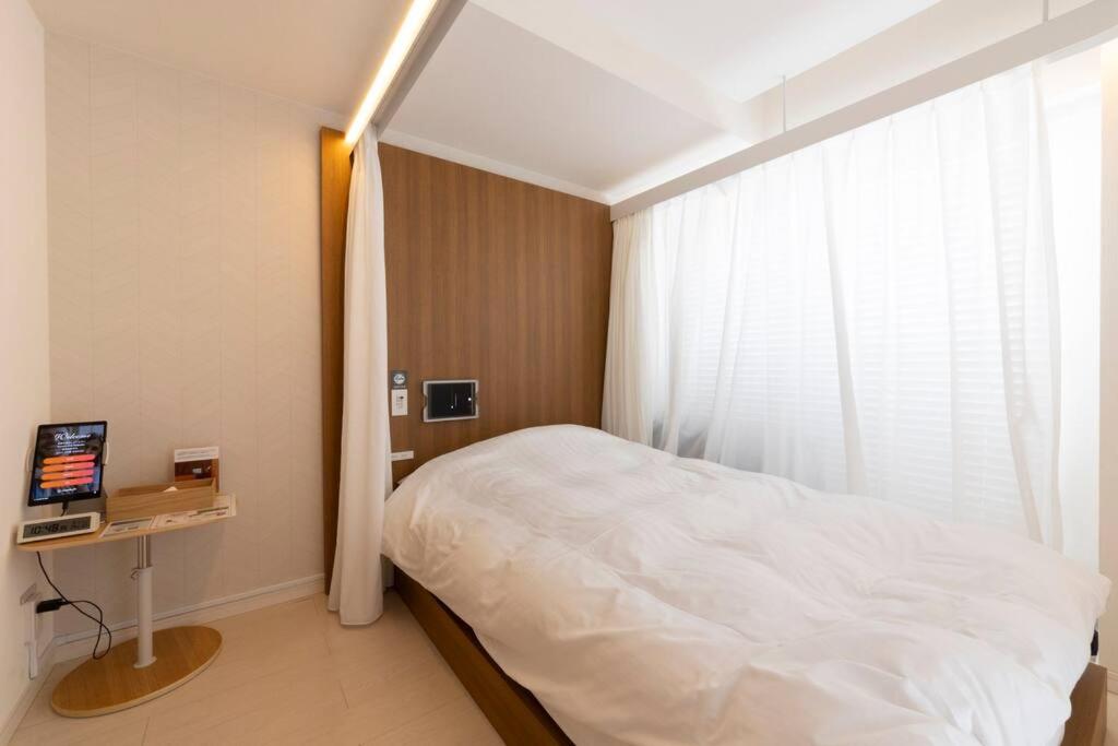 1 dormitorio con cama blanca y ventana en SLEEPLAB THE STAY 渋谷 -睡眠特化型Hotel-, en Tokio