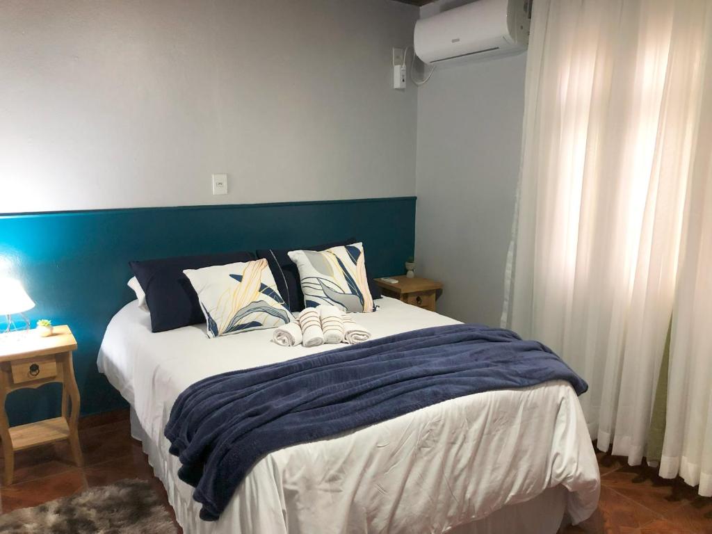Schlafzimmer mit einem großen Bett mit blauem Kopfteil in der Unterkunft Residência Vô José - Casa 02 in Pomerode