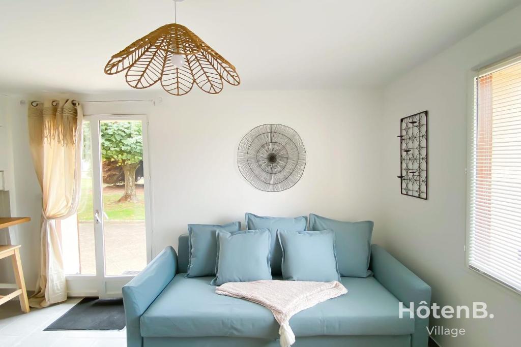 Sofá azul en la sala de estar con lámpara de araña en Green Haven T2 with Large Garden en Panazol